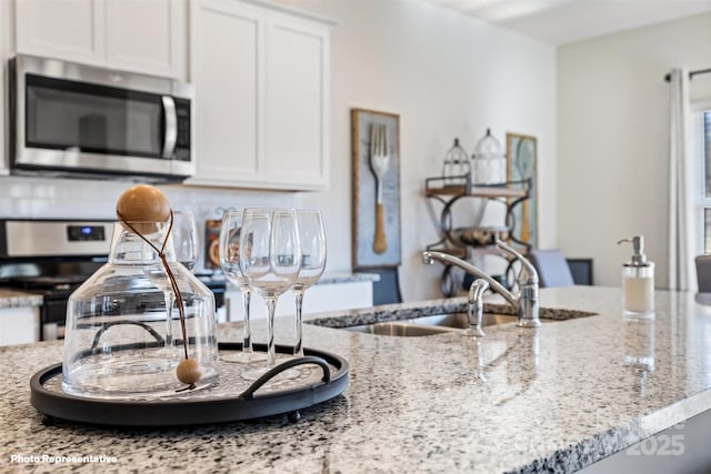 1406 5th Street Dr NE, Hickory, NC 28601 - kitchen featuring stainless steel appliances, white cabinets, light stone counters, and backsplash
