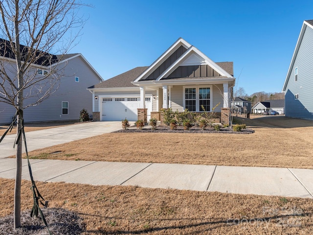 craftsman inspired home with a garage, a front yard, and a porch