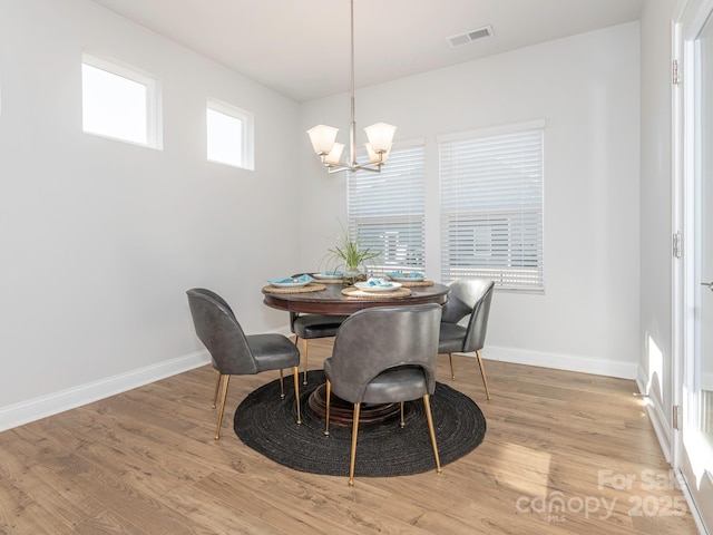 dining area featuring an inviting chandelier and light hardwood / wood-style flooring