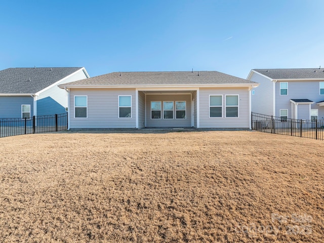 rear view of property featuring a lawn