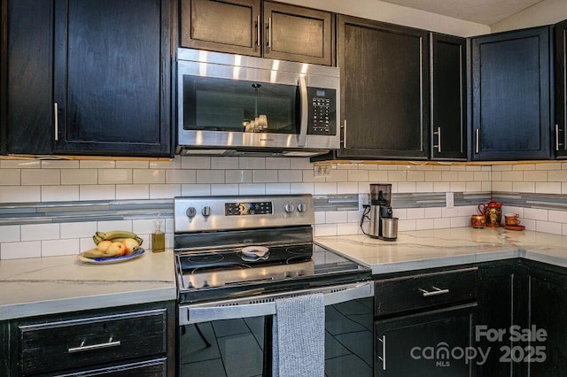 kitchen with decorative backsplash, light stone countertops, and stainless steel appliances