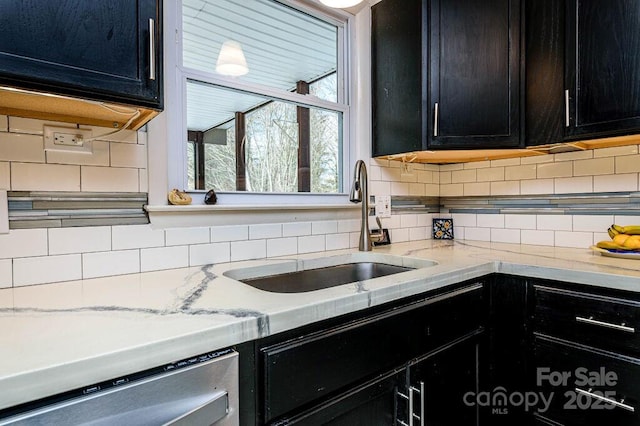 kitchen with dishwasher, decorative backsplash, light stone countertops, and sink