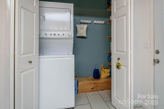 washroom with light tile patterned floors and stacked washer and clothes dryer