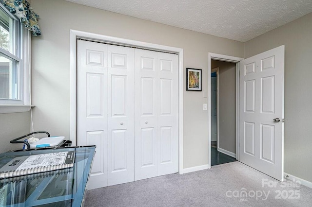 bedroom with carpet, a closet, and a textured ceiling