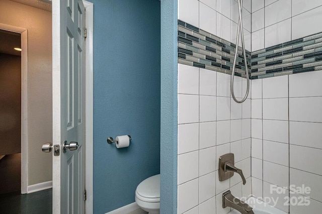 bathroom with toilet and tiled shower / bath combo