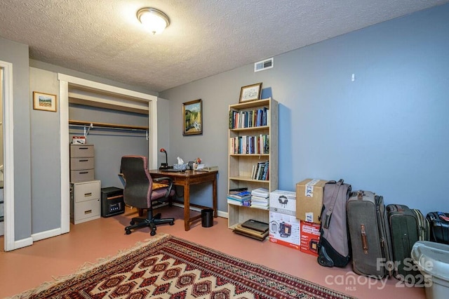 home office with a textured ceiling and concrete floors