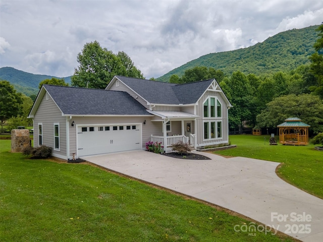 view of front of property with a front yard, a mountain view, a garage, a gazebo, and covered porch