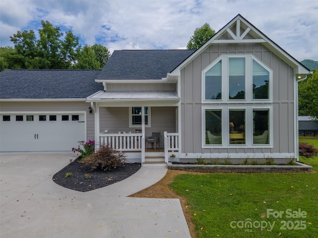 view of front of property with a garage, a front yard, and covered porch