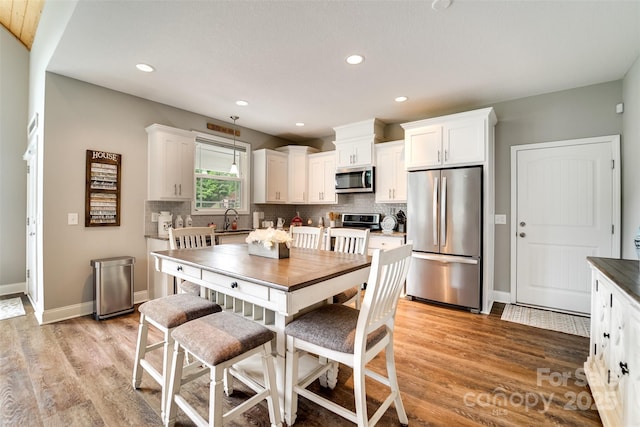 kitchen featuring white cabinets, sink, stainless steel appliances, and light hardwood / wood-style floors