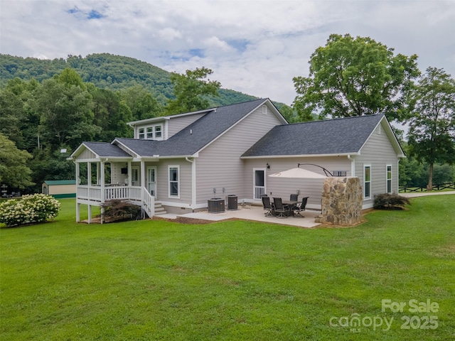 rear view of house with a patio area, cooling unit, and a yard