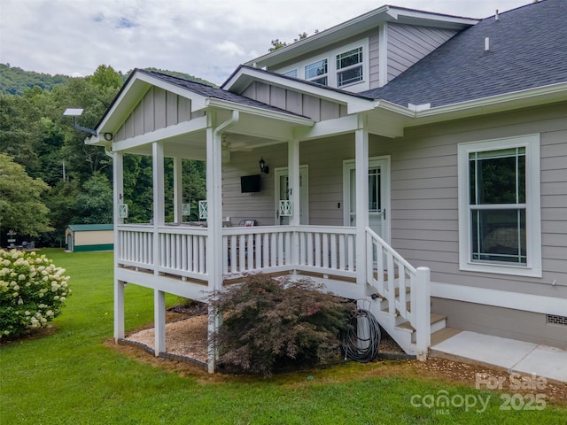 entrance to property with covered porch and a lawn