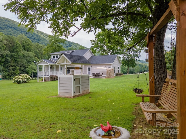 view of yard with a mountain view and covered porch