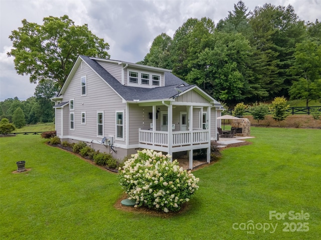 rear view of property with covered porch, a gazebo, and a yard