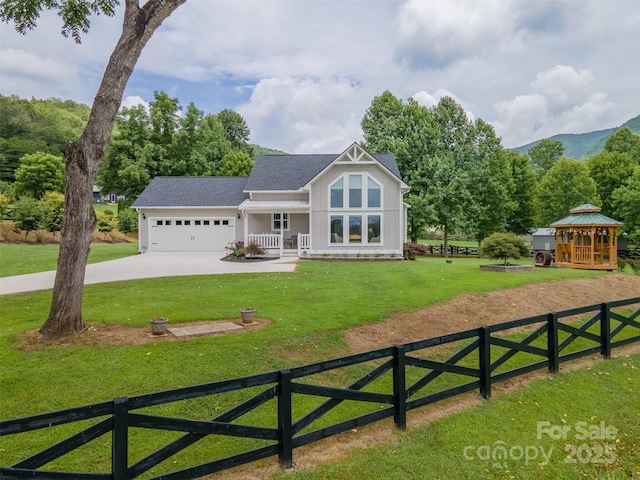 view of front of house with a garage, a front yard, and a gazebo