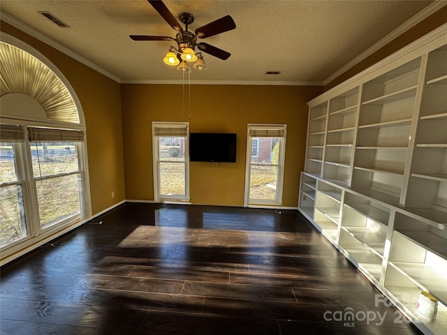 empty room with ceiling fan, dark wood-type flooring, crown molding, and a textured ceiling