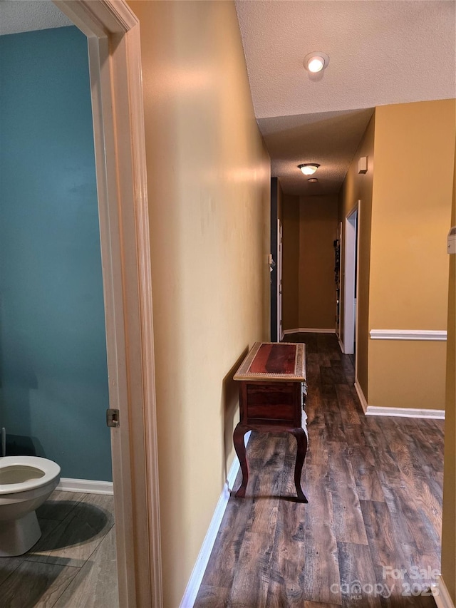 hallway featuring dark hardwood / wood-style floors and a textured ceiling