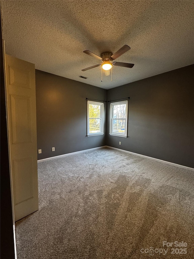 carpeted empty room with a textured ceiling and ceiling fan