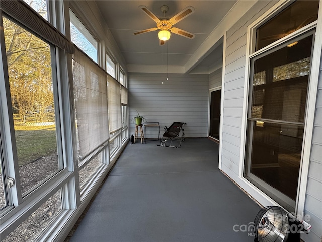 unfurnished sunroom with ceiling fan