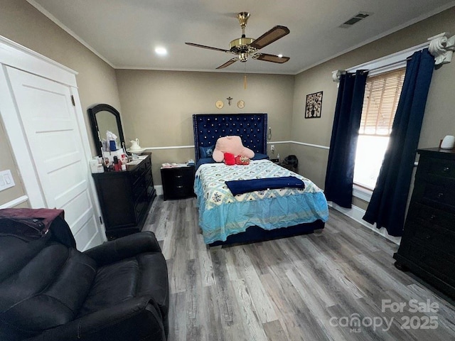 bedroom with ceiling fan, crown molding, and hardwood / wood-style floors