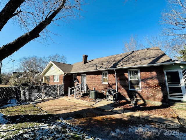 rear view of property with central AC