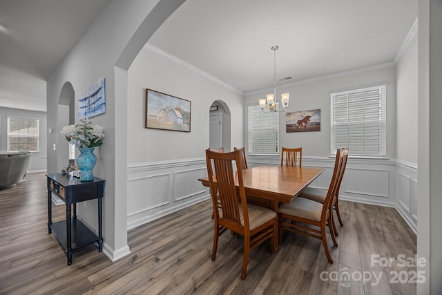 dining area featuring hardwood / wood-style flooring, crown molding, and a chandelier