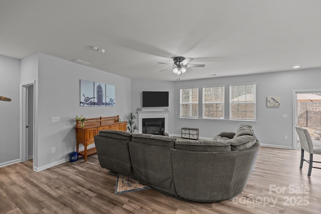 living room featuring ceiling fan and light hardwood / wood-style floors