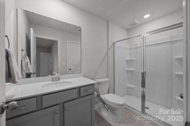 bathroom featuring vanity, tile patterned flooring, a shower with shower door, and toilet