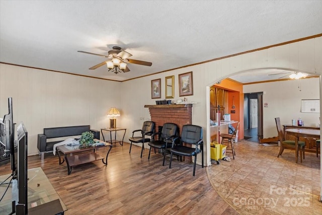 living room featuring a fireplace, hardwood / wood-style flooring, a textured ceiling, and ceiling fan