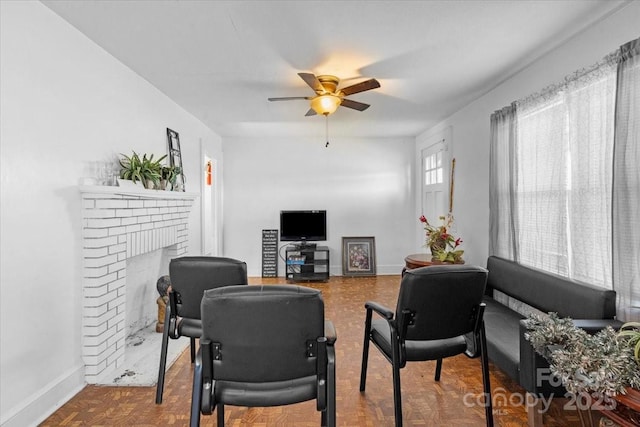 living room featuring ceiling fan, parquet flooring, and a brick fireplace