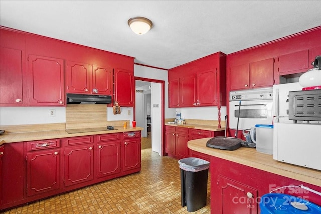 kitchen featuring backsplash, oven, and black electric cooktop