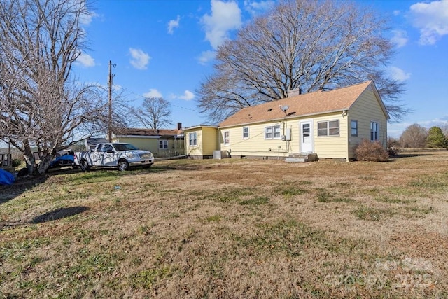 back of property with a lawn