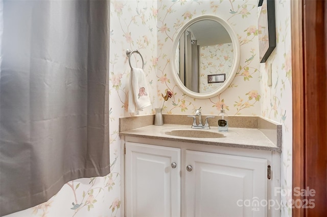 bathroom featuring vanity and wallpapered walls