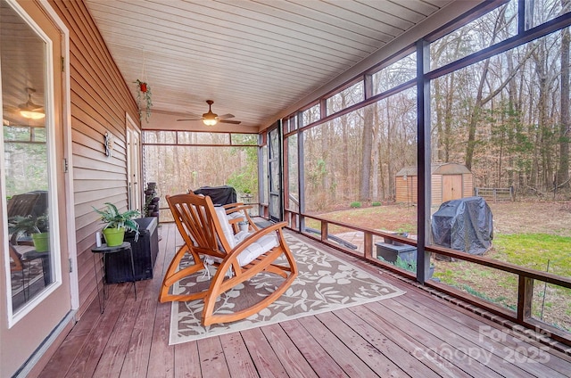 sunroom / solarium featuring ceiling fan, plenty of natural light, and wooden ceiling