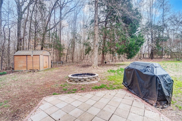 view of yard featuring a patio, a storage unit, an outdoor fire pit, and an outdoor structure