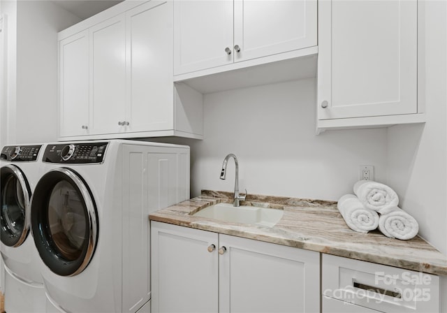 clothes washing area featuring cabinets, washer and clothes dryer, and sink