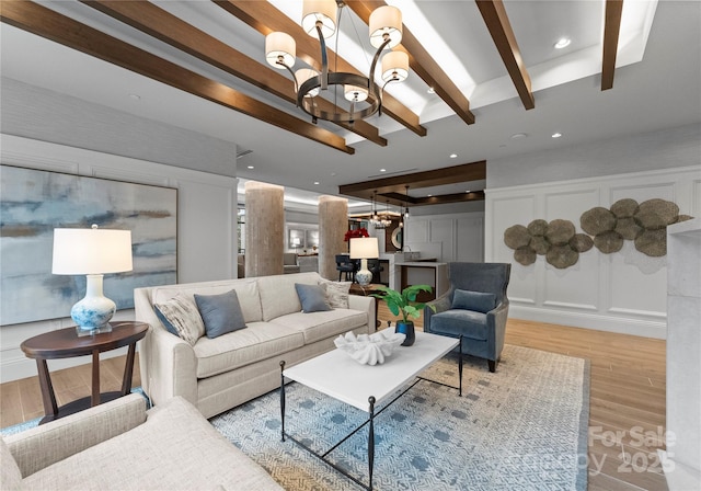 living room with a notable chandelier, beam ceiling, and light hardwood / wood-style floors