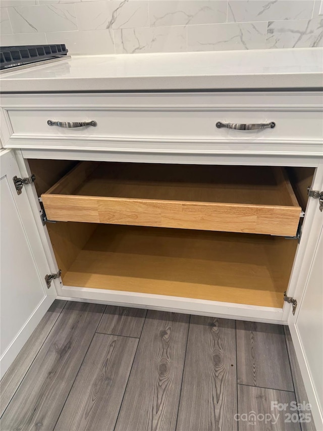 details with dark hardwood / wood-style flooring and white cabinetry