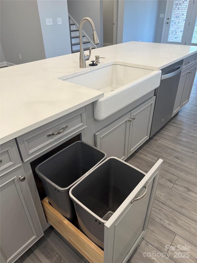 kitchen featuring dishwasher, sink, and gray cabinets