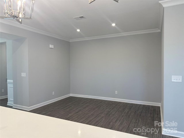 empty room featuring dark wood-type flooring, crown molding, and an inviting chandelier