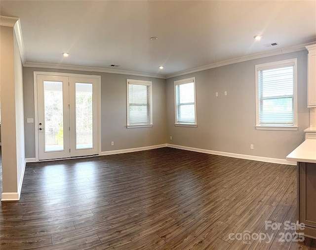 spare room featuring dark wood-type flooring and crown molding