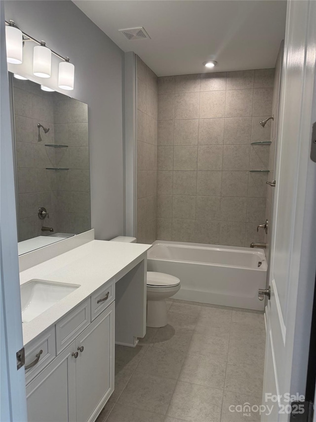 full bathroom with toilet, tile patterned flooring, tiled shower / bath combo, and vanity