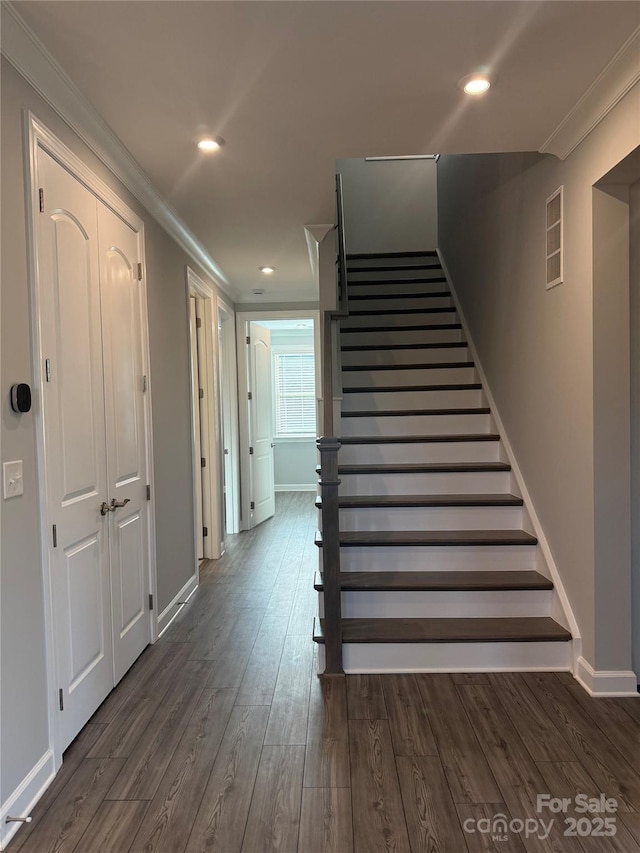 stairs with wood-type flooring and ornamental molding