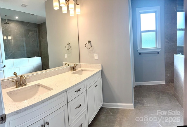 bathroom featuring tile patterned flooring, tiled shower, and vanity