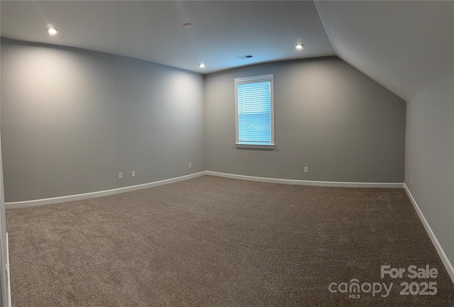 additional living space featuring carpet and vaulted ceiling