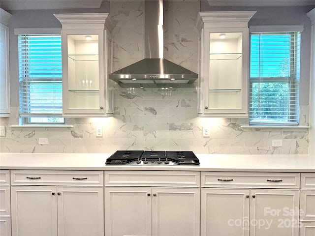 kitchen with white cabinets, light countertops, wall chimney range hood, and stainless steel gas stovetop