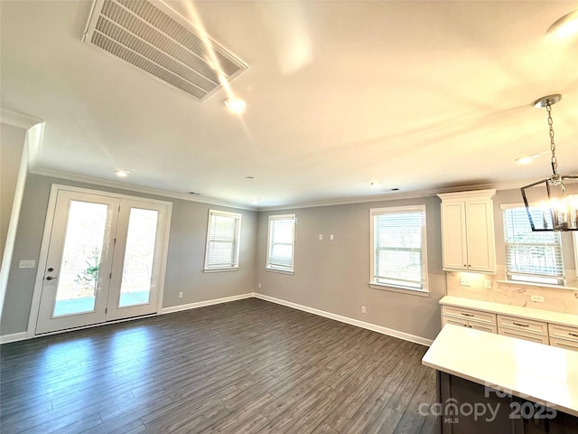 interior space with light countertops, a wealth of natural light, visible vents, and dark wood-style flooring