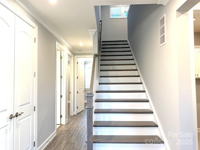 staircase featuring a wealth of natural light, wood finished floors, ornamental molding, and recessed lighting