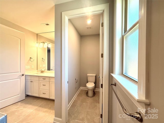 bathroom featuring a wealth of natural light, visible vents, toilet, and vanity