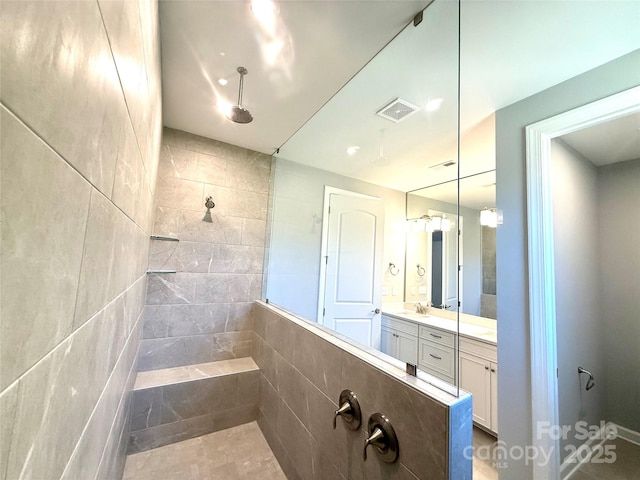 bathroom featuring vanity, a walk in shower, and visible vents