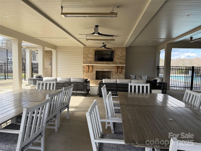 view of patio with an outdoor living space with a fireplace, outdoor dining area, fence, and ceiling fan